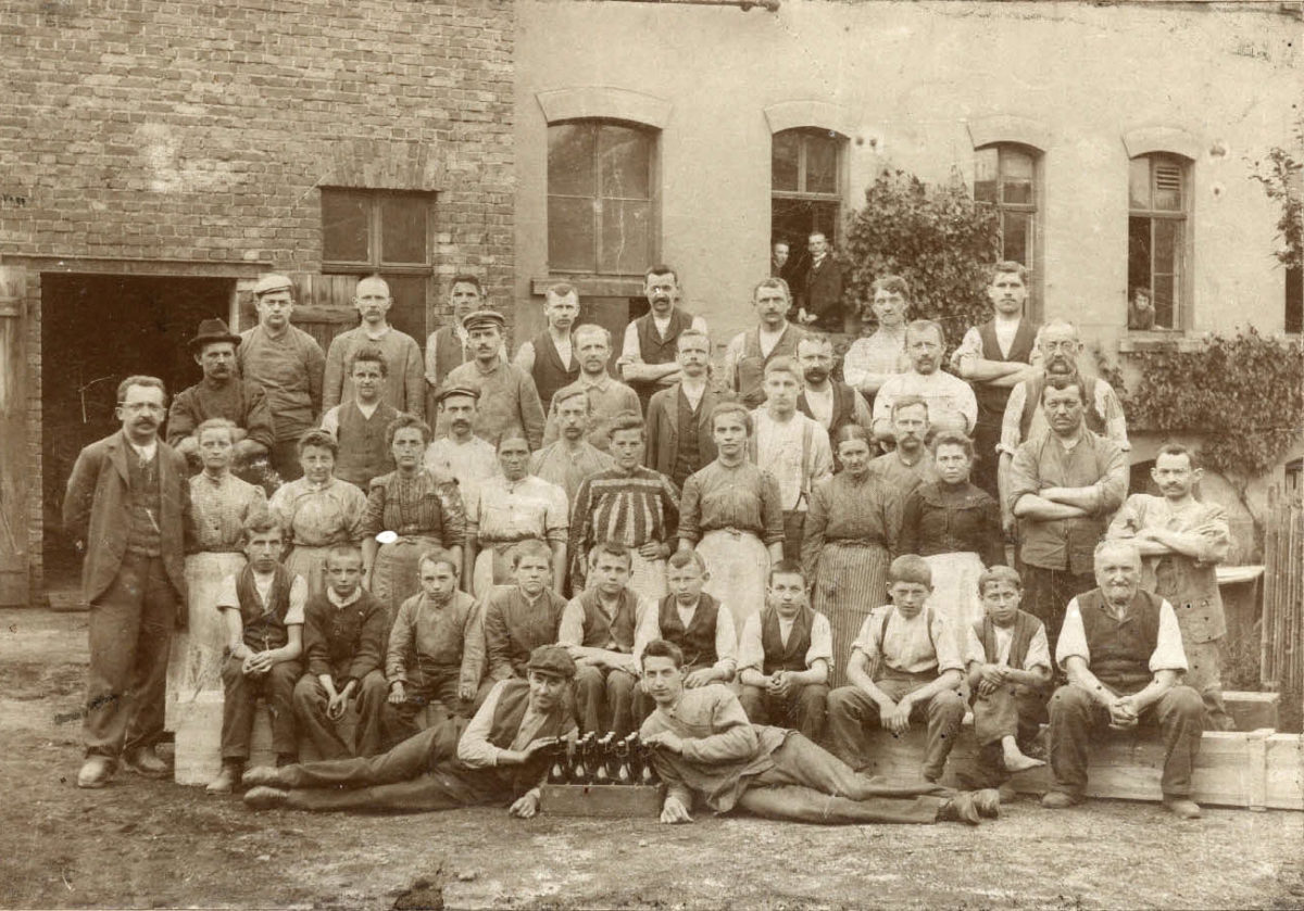 Die Belegschaft vor den Fabrikgebäuden, ganz links der Inhaber Rudolf vom Hau, 1904 (Kreismuseum Grimma)
