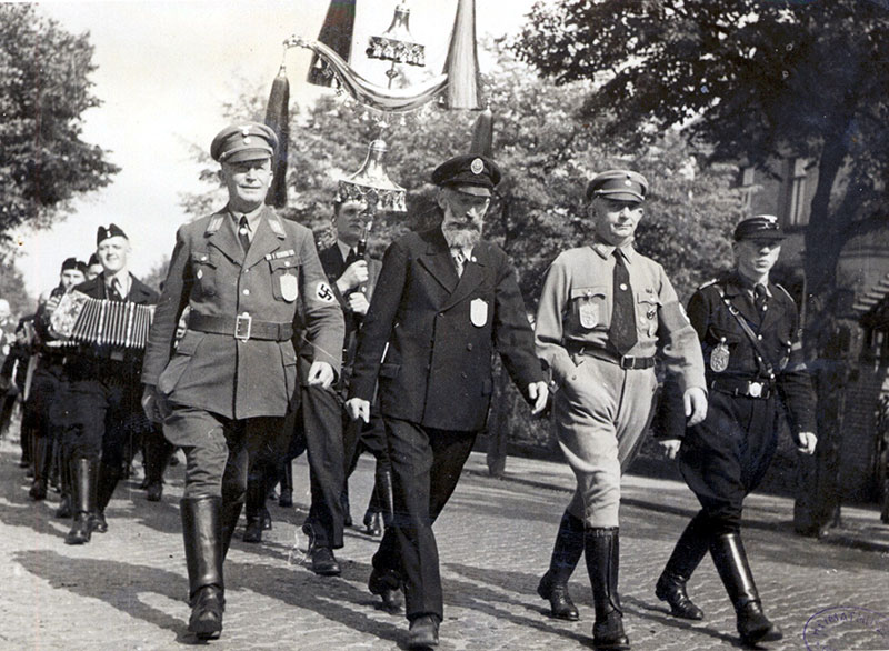 Walther zwischen Ortsgruppenleiter Wappler (li.) und seien Stellvertreter Böttger (re.) auf dem Marsch zur Siedlung, Foto 1937 (Kreismuseum Grimma)